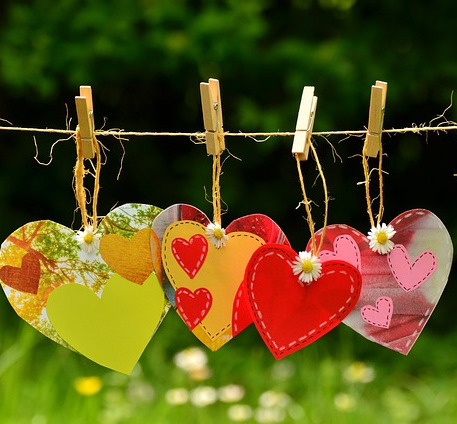 Stock image of hand made paper hearts hanging on strinhg.